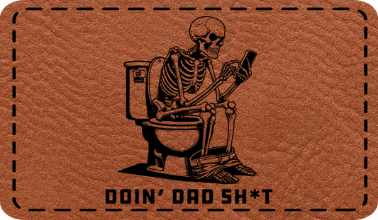 Close-up of the "Doin' Dad Sh*t" leatherette patch featuring a skeleton on a toilet looking at a phone.