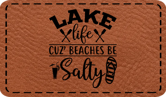 Close-up of the "Lake Life Salty Beaches" leatherette patch featuring playful text.