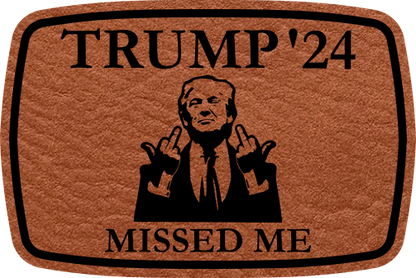 Close-up of the "Missed Me" leatherette patch featuring Trump’s message and middle finger.