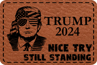 Close-up of the "Nice Try. Still Standing" leatherette patch featuring Trump with aviators and American flags in the lenses.